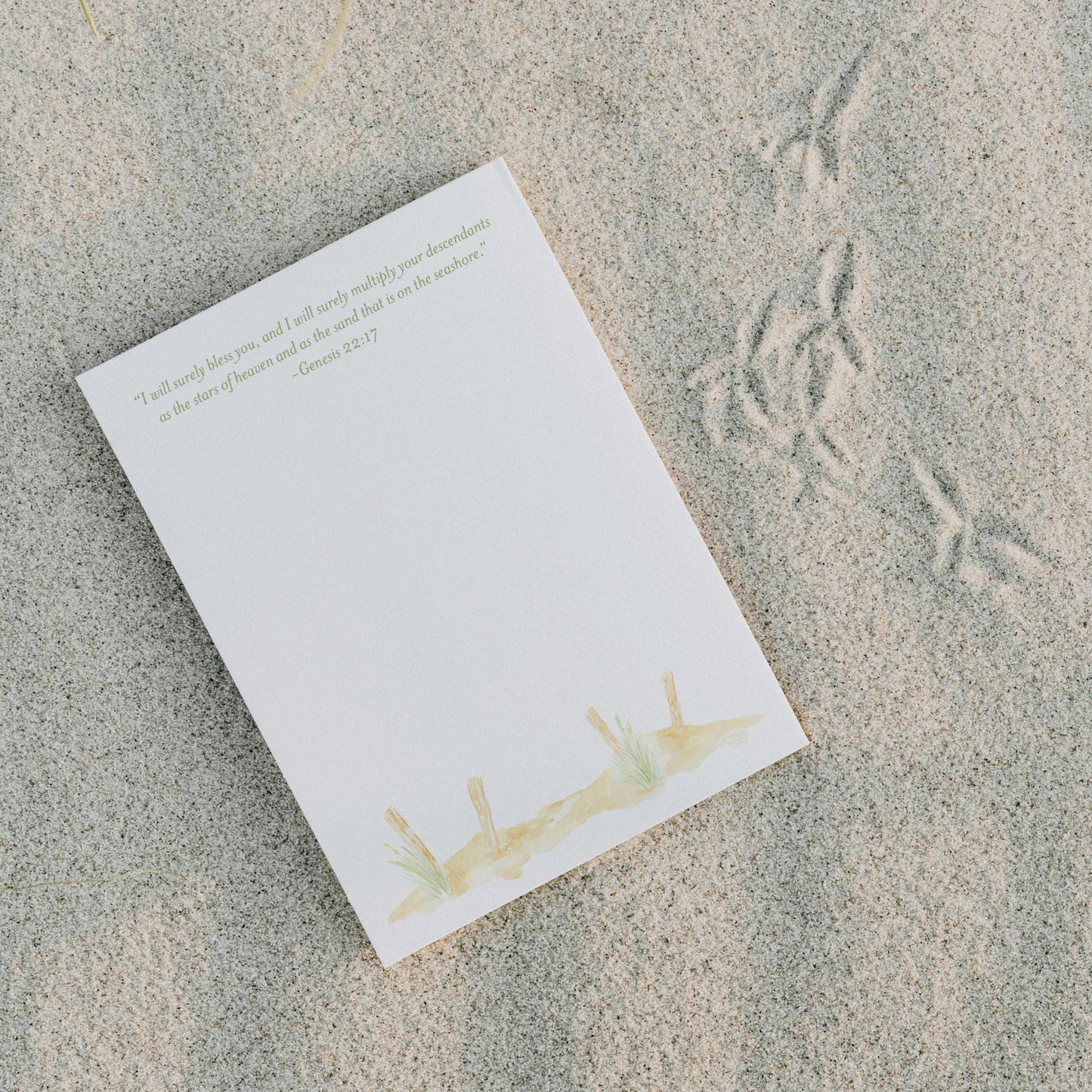 a piece of paper sitting on top of a sandy beach