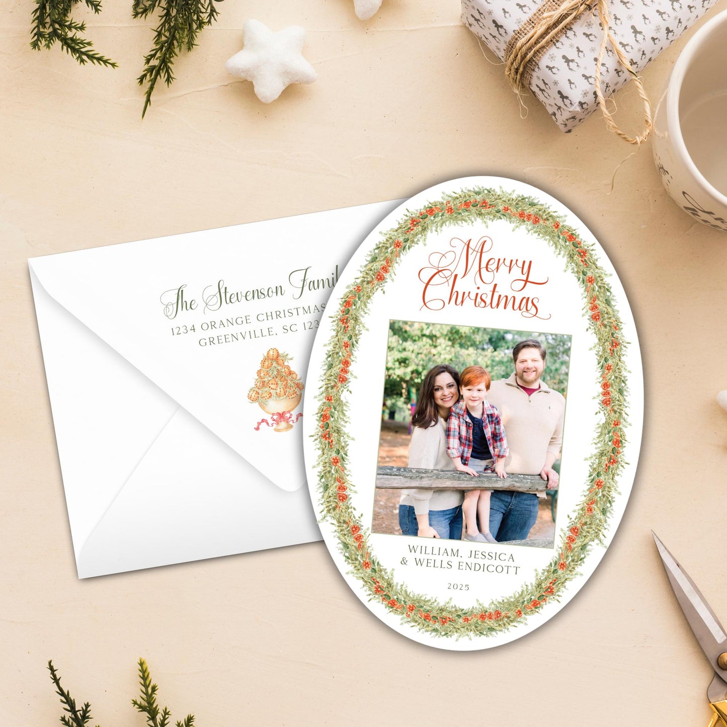 a Christmas card with a family photo and a white envelope with a holiday-themed stamp.