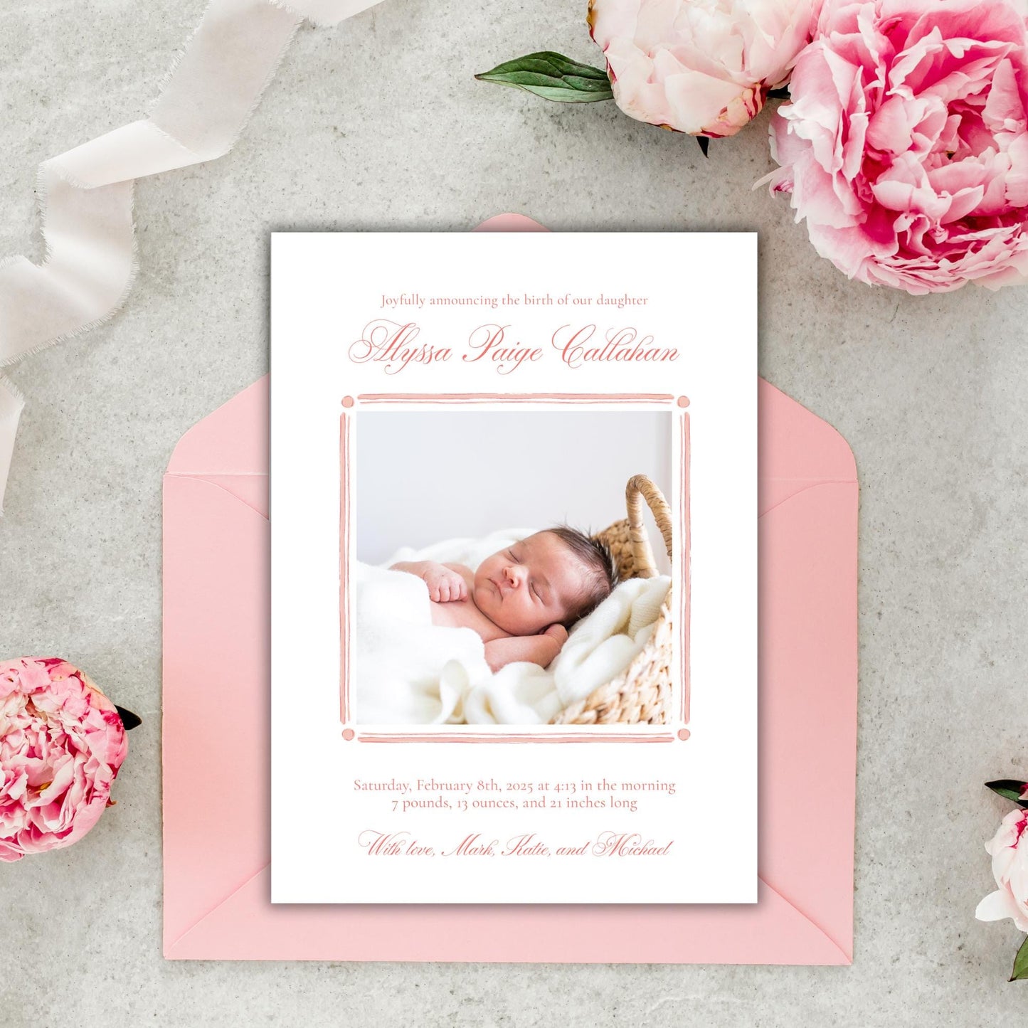 a pink envelope with a photo of a baby on it
