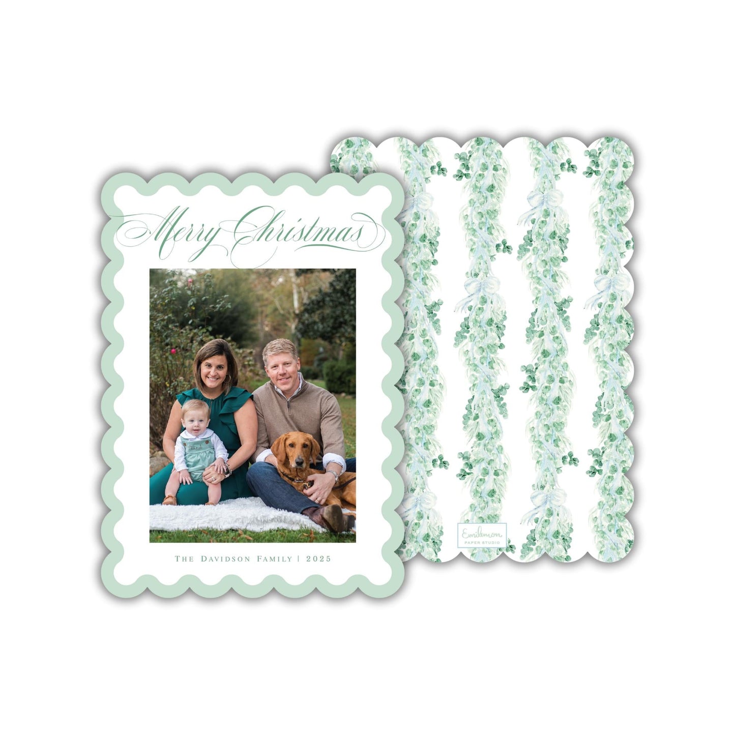 A family portrait of a couple and their child, with a dog in the background, is displayed on a green and white scalloped card.