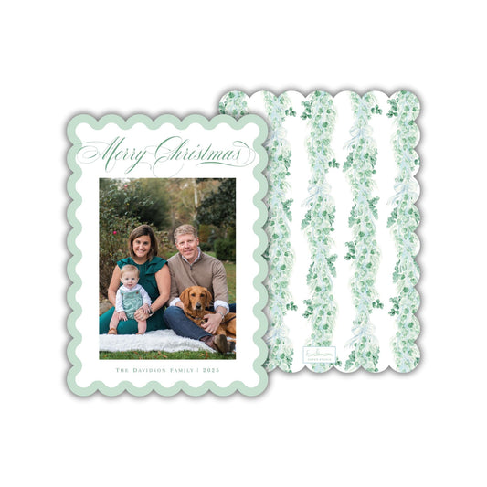A family portrait of a couple and their child, with a dog in the background, is displayed on a green and white scalloped card.
