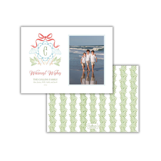 A greeting card featuring a photo of three children on the beach, along with a decorative element and text wishing warmest wishes.