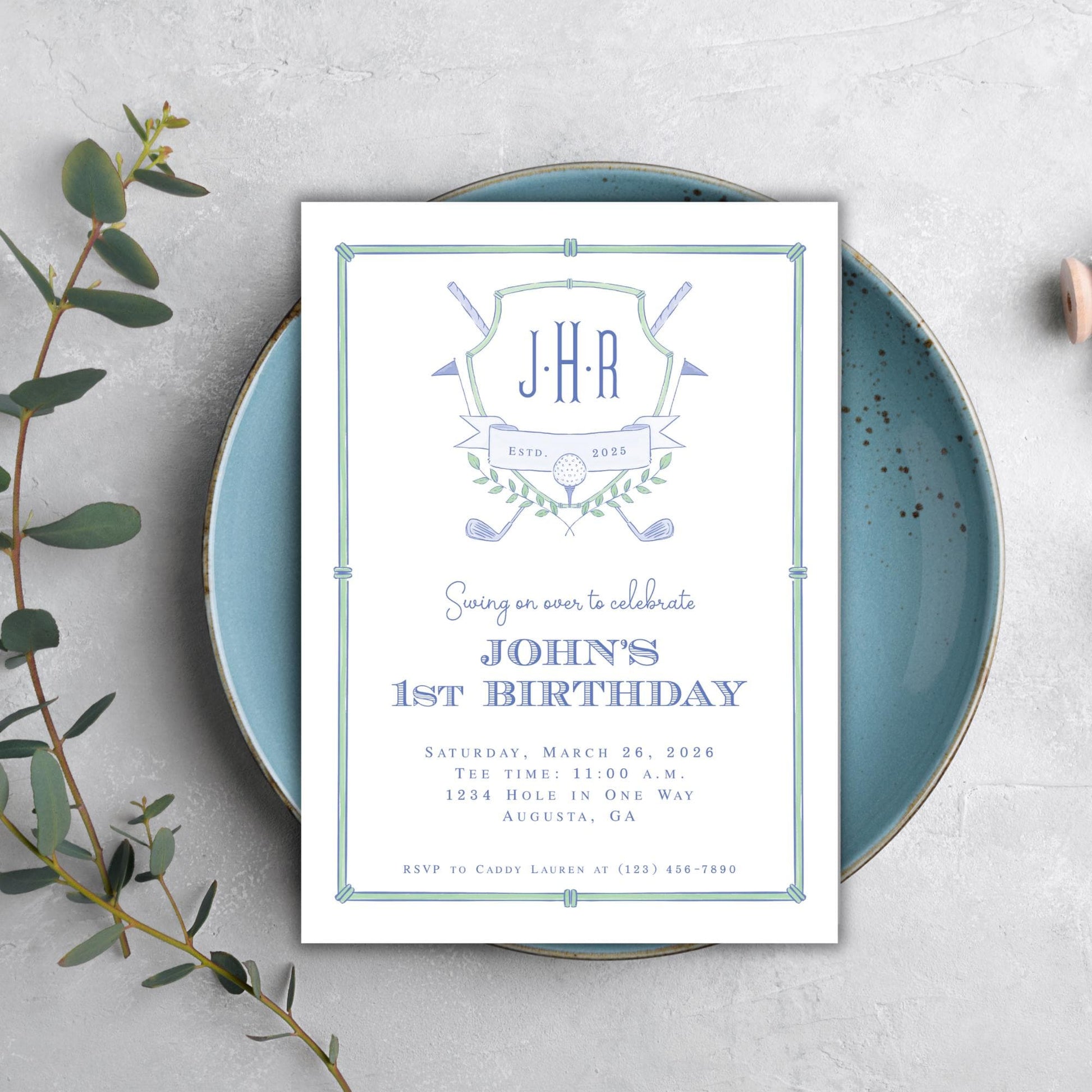 A birthday invitation for John's 1st birthday celebration, featuring a blue plate and a plant on a white background.