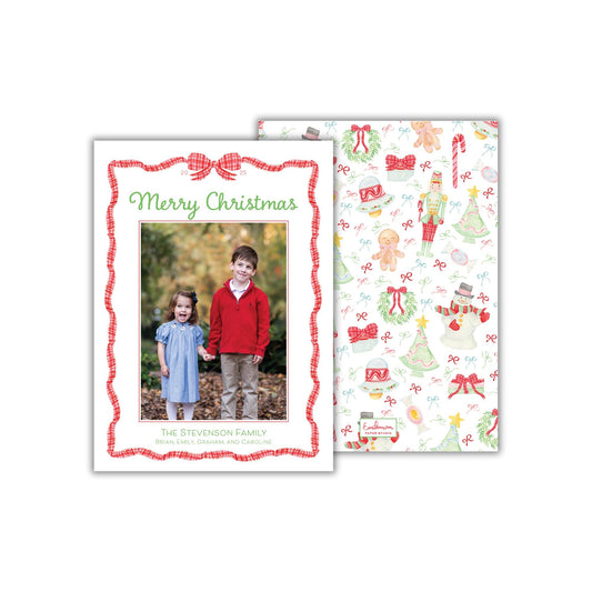 A Christmas-themed card featuring a photo of two children, a boy and a girl, standing together in a forest setting. The card has a red and white border and a festive design with Christmas-related elements such as trees, snowmen, and candy canes.