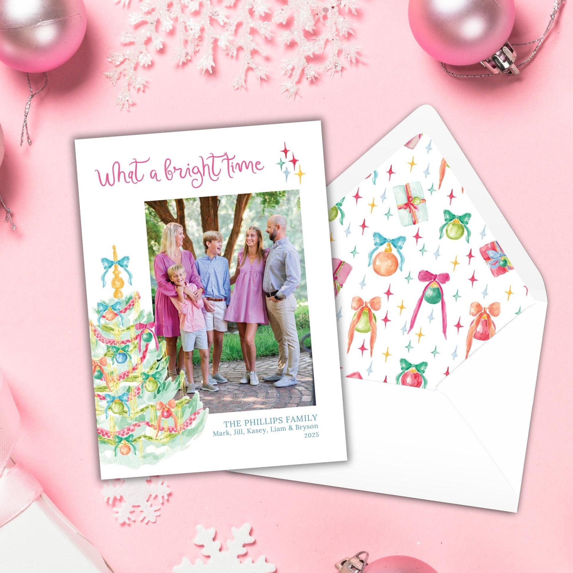 A family photo is displayed on a pink background, accompanied by a white envelope with a festive pattern and a pink ornament.