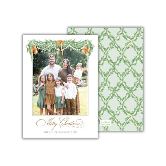 A family portrait of a man, woman, and children, with a festive holiday theme, is displayed on a white card with a green and white patterned background.