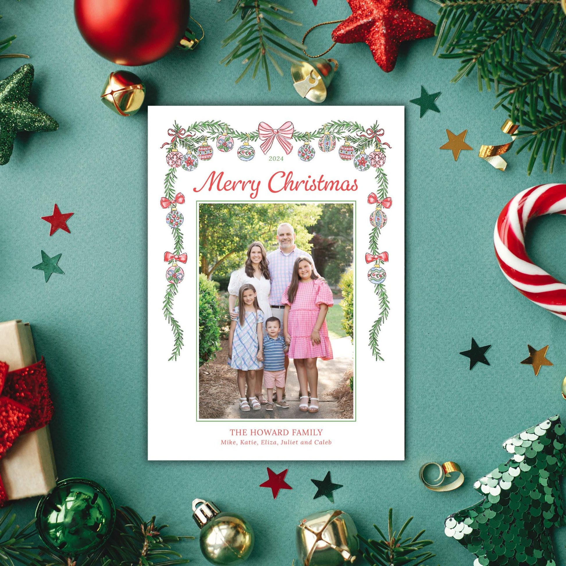 A family photo is displayed in the center of the image, surrounded by various Christmas decorations such as ornaments, tinsel, and a star.