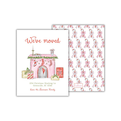 The image is a Christmas-themed greeting card with a pink and white color scheme. It features illustrations of a house, stockings, and candy canes, along with the text "We've moved" and the address "1234 Christmas Stocking In Greenville, SC 29245 Love the Swanson Family".