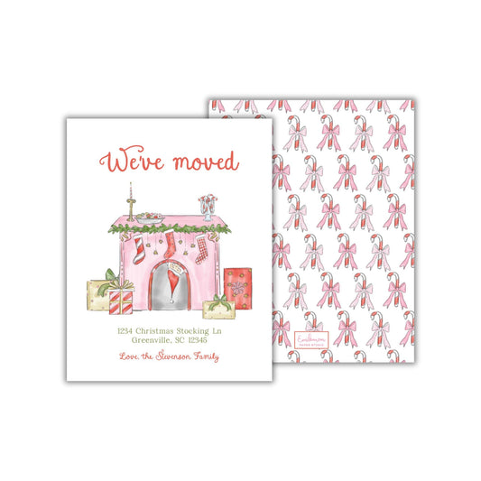 The image is a Christmas-themed greeting card with a pink and white color scheme. It features illustrations of a house, stockings, and candy canes, along with the text &quot;We&#39;ve moved&quot; and the address &quot;1234 Christmas Stocking In Greenville, SC 29245 Love the Swanson Family&quot;.