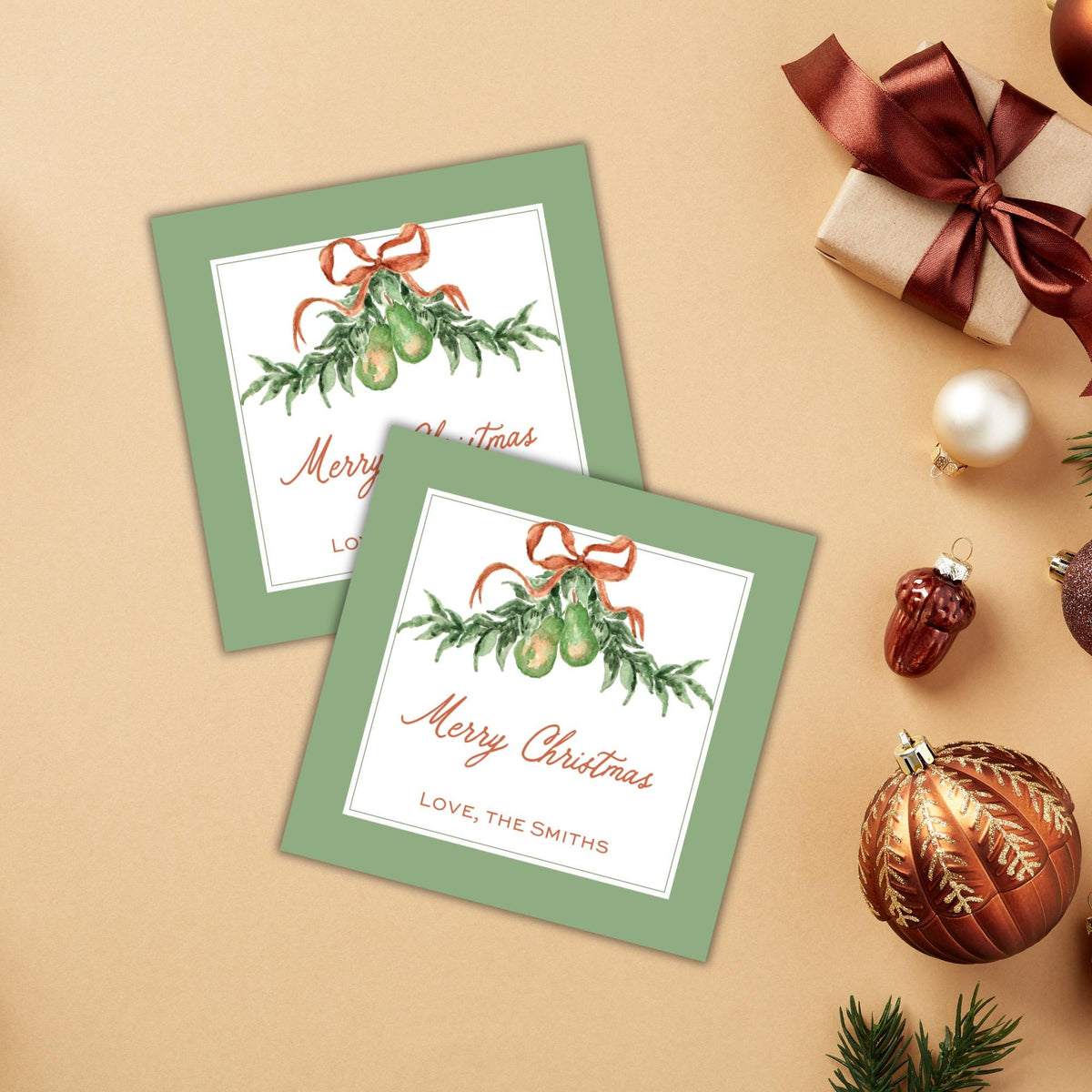 a pair of green greeting cards with a festive Christmas theme, along with various holiday decorations such as ornaments, a gift box, and a ribbon.