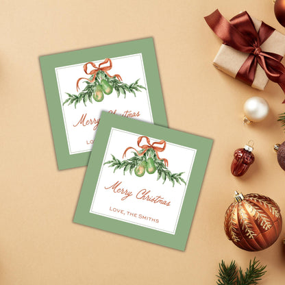 a pair of green greeting cards with a festive Christmas theme, along with various holiday decorations such as ornaments, a gift box, and a ribbon.