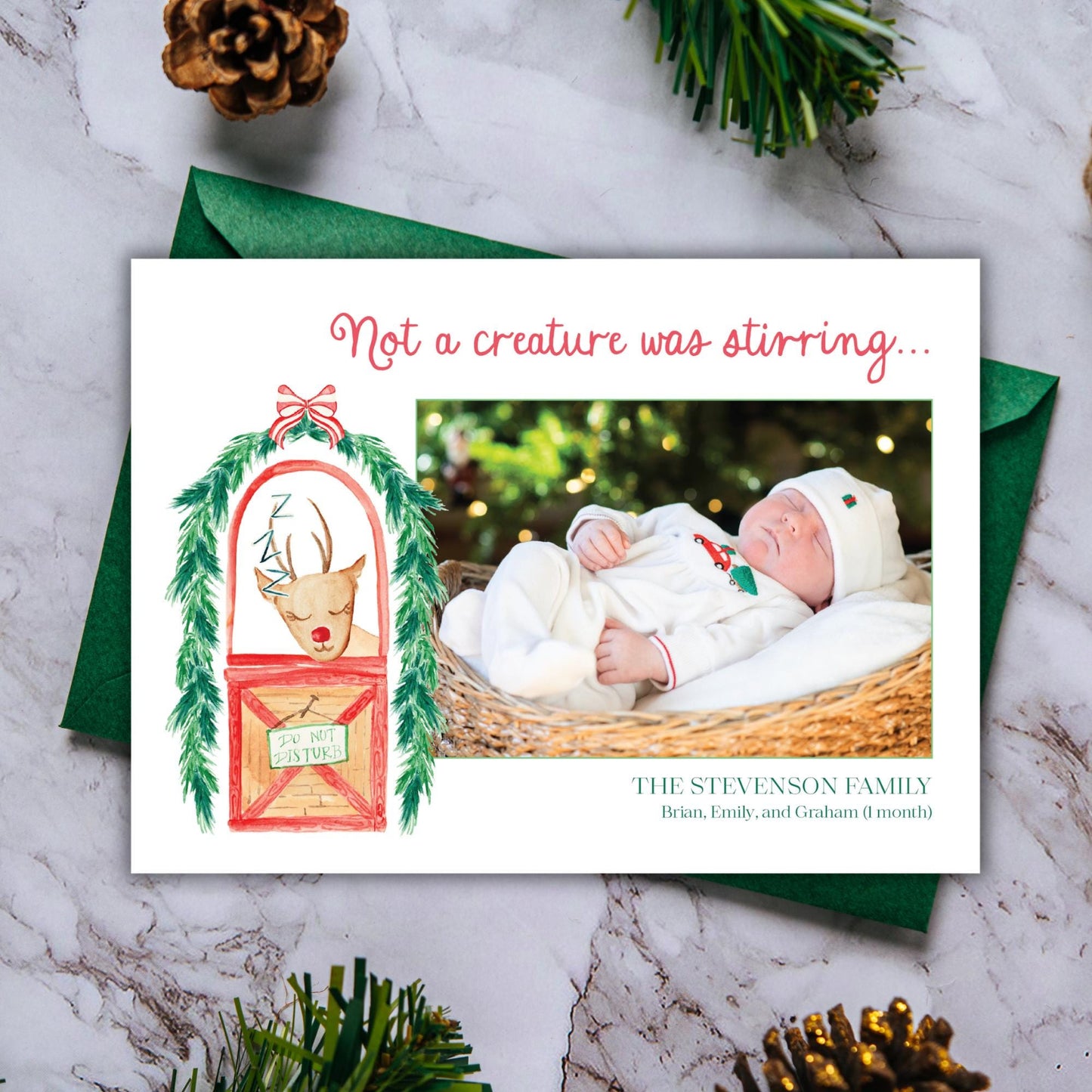 A Christmas card featuring a baby in a basket, with a reindeer illustration and a caption that reads &quot;Not a creature was stirring...&quot;
