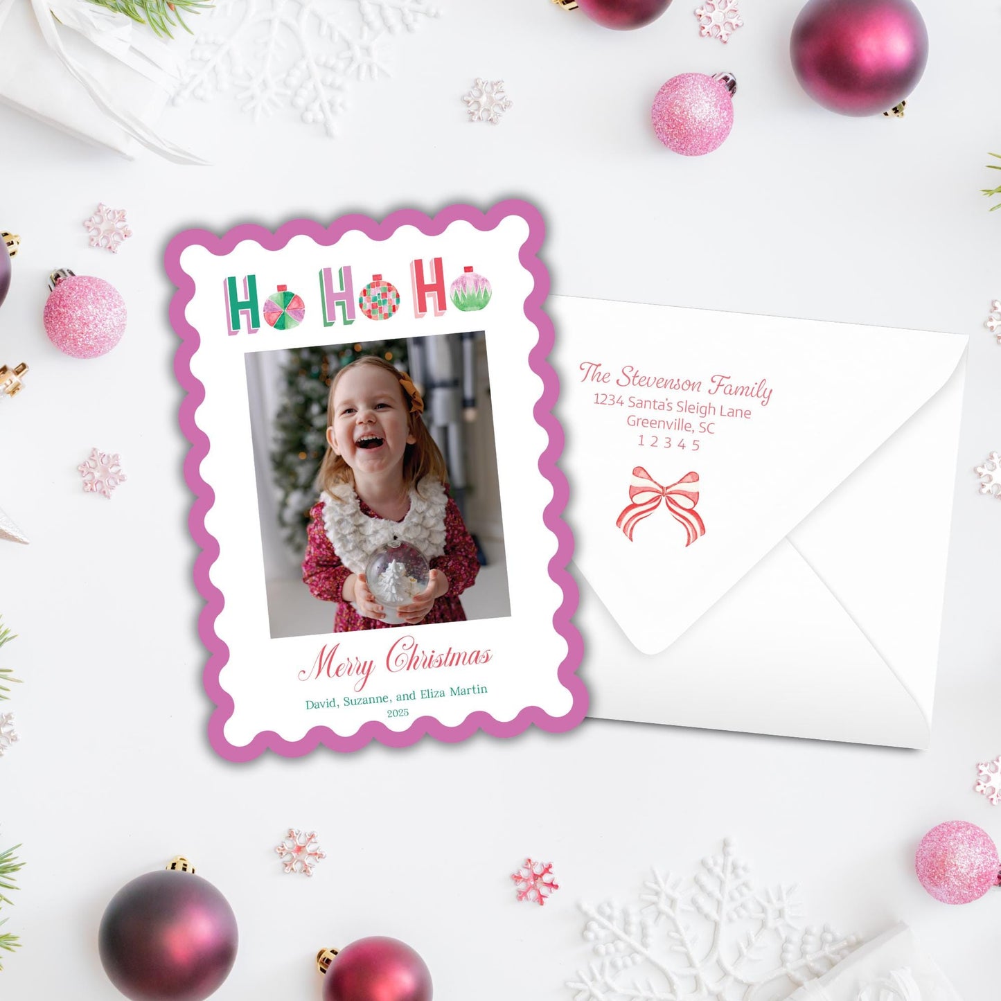 A Christmas card with a photo of a young girl smiling, surrounded by ornaments and snowflakes on a white background.