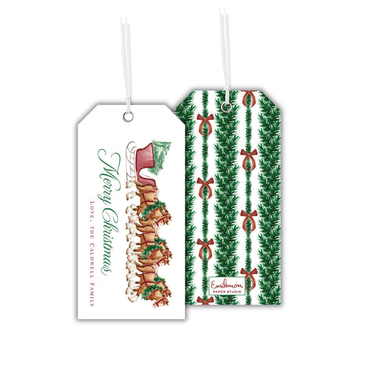 two Christmas-themed gift tags, one with a sleigh and reindeer design and the other with a repeating pattern of green pine trees and red bows.