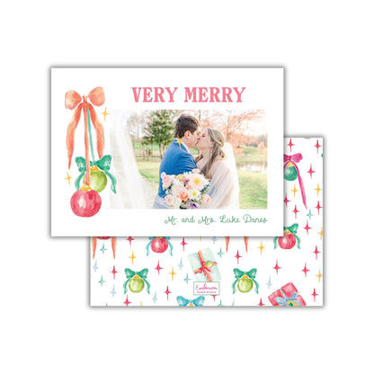 A couple embracing in a romantic moment, surrounded by festive decorations and a "Very Merry" greeting card.