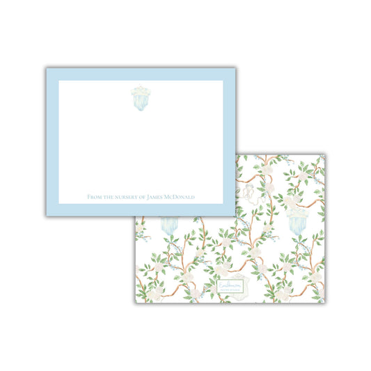 two pieces of paper with different designs. The top paper has a plain white background with a blue border and a small illustration of a flower. The bottom paper has a floral pattern with green leaves and branches.