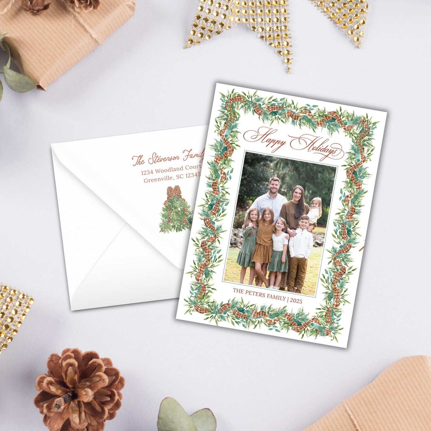 A holiday greeting card with a family photo and a white envelope with a holiday-themed design.