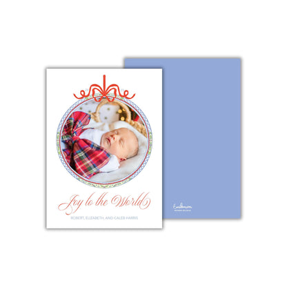 A white card with a photo of a sleeping baby and a decorative border, along with the text "Joy to the World" and the names "Robert, Elizabeth, and Caleb Harris".