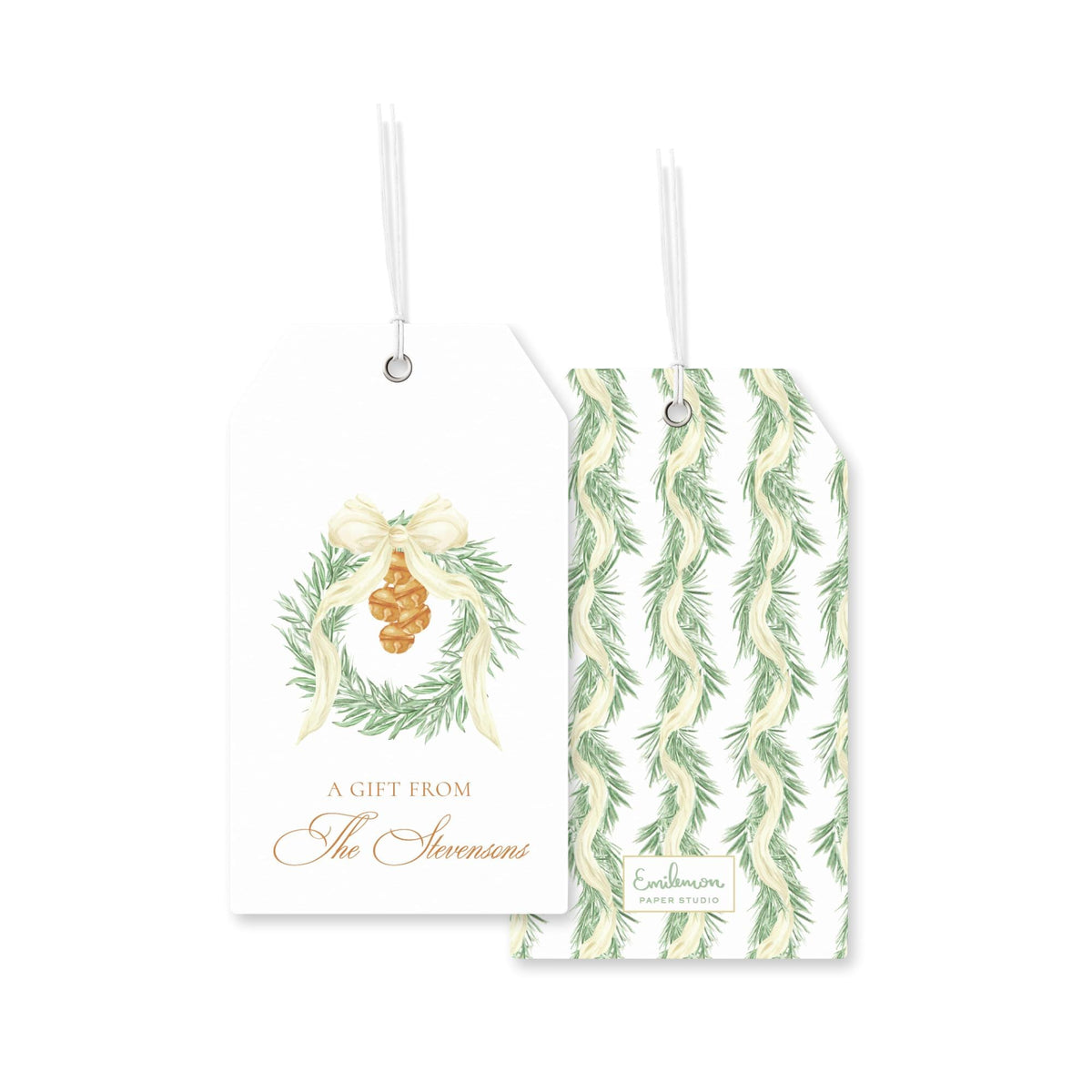 two white tags with holiday-themed designs. The tag on the left has a wreath and a pine cone, and the tag on the right has a repeating pattern of green leaves.