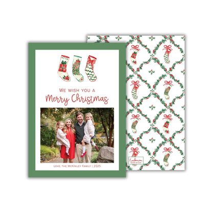 A Christmas card featuring a family photo and a patterned background with Christmas stockings and greenery.