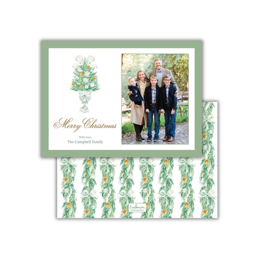 A Christmas card featuring a family photo and a decorative tree with orange ornaments.