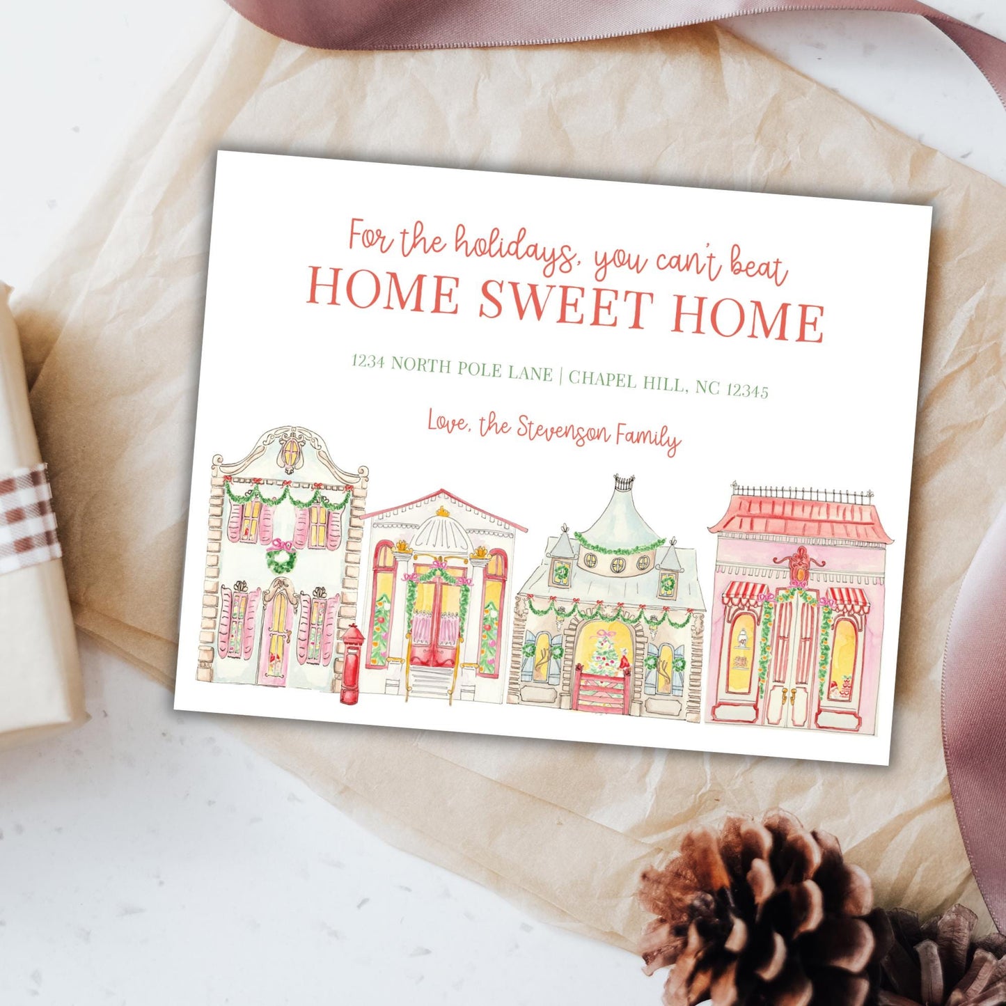 A holiday-themed card with illustrations of colorful houses and a ribbon, placed on a white surface.