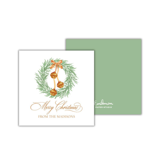 A Christmas card with a wreath and bells on it, along with the text &quot;Merry Christmas FROM THE MADISONS&quot; printed on it.