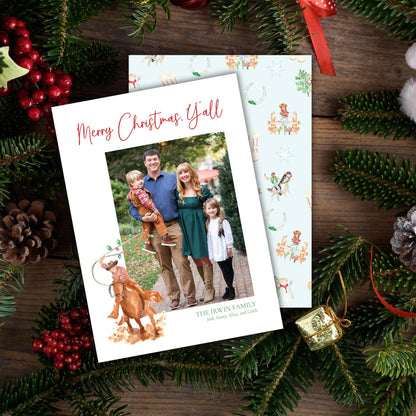 A Christmas card featuring a family photo surrounded by holiday decorations such as pine cones, berries, and ornaments.