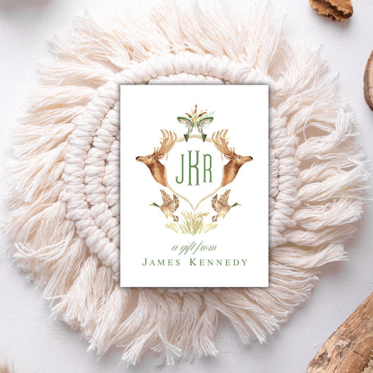 A white card with a decorative border featuring a deer and two birds, surrounded by a white shawl.
