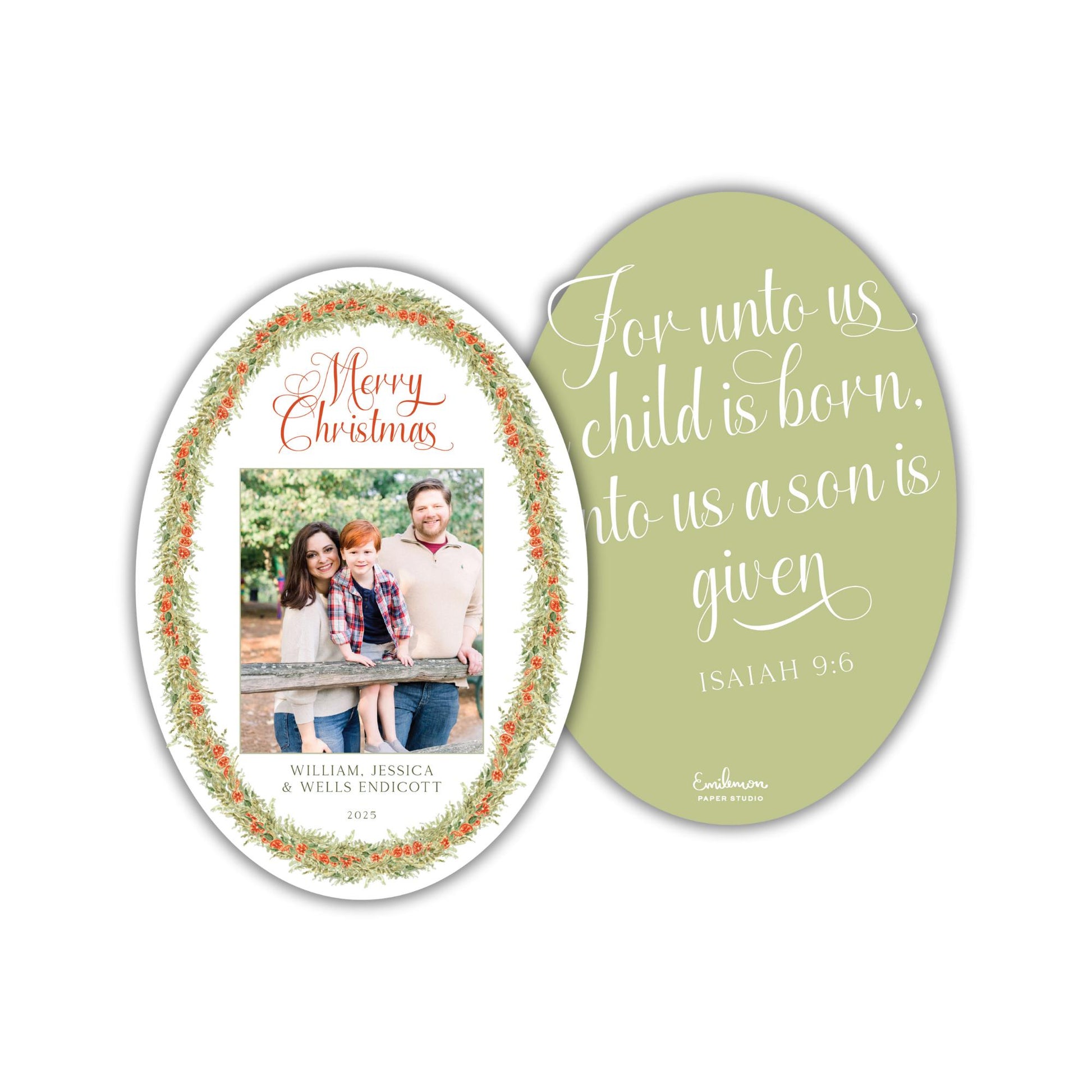 The image is a Christmas card featuring a family photo of a man, woman, and child. The card has a green oval background with a floral border and a message that reads &quot;For unto us child is born. into us a son is given. Isaiah 9:6&quot;.