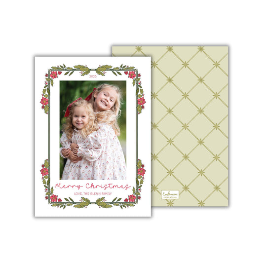 A Christmas card featuring two young girls in a floral frame, with a patterned background.