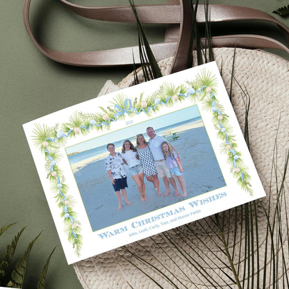 A family photo is displayed on a card with a tropical-themed border, surrounded by a straw hat and other natural elements.