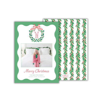 A Christmas card featuring a young girl in a red and white outfit, with a wreath and ribbon design, and a photo of her on the front.