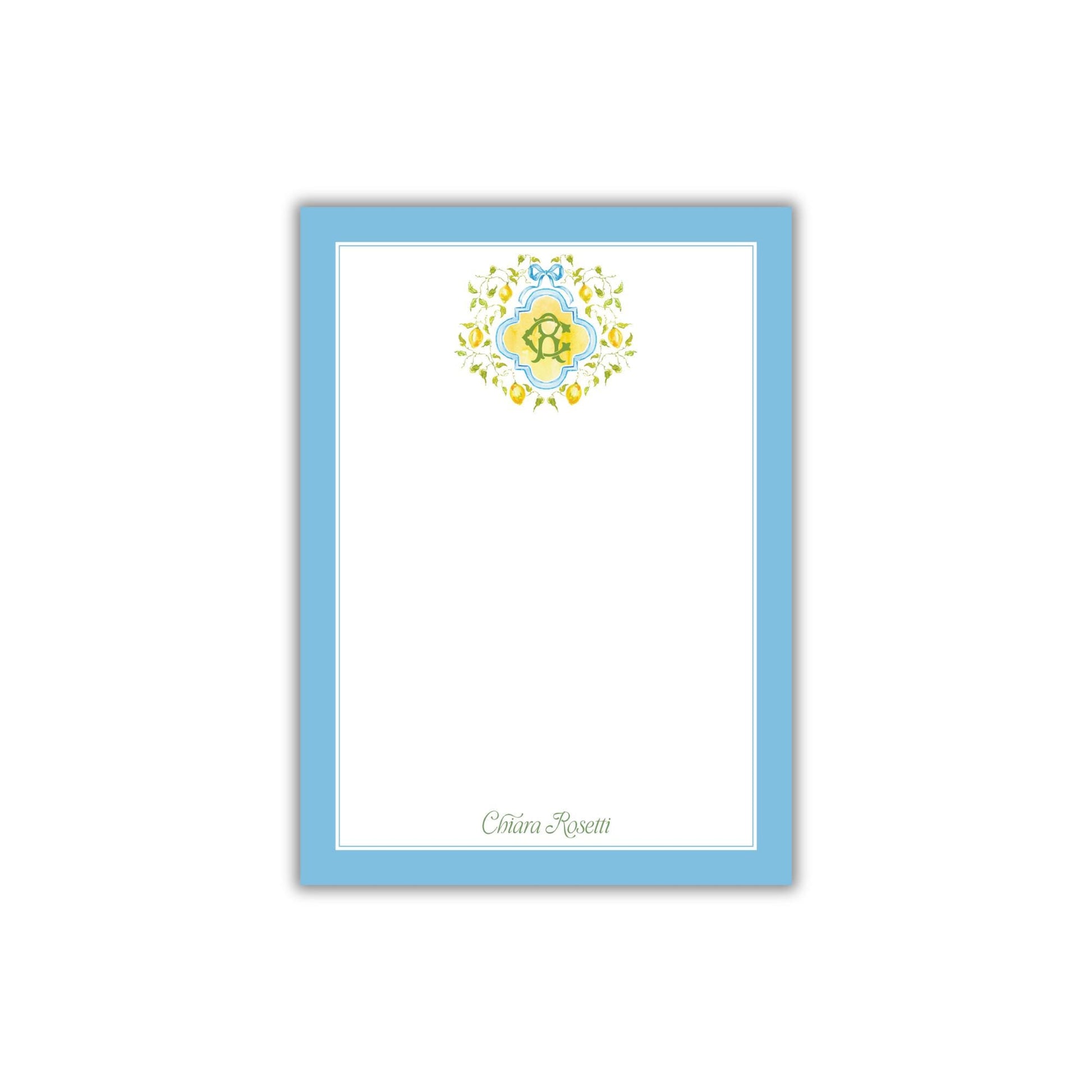 A blue-bordered, white-blank card with a decorative floral design on the top.
