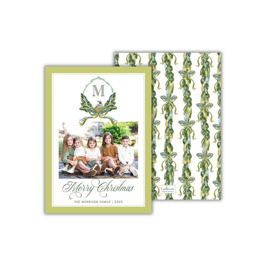A family photo of five children sitting together, with a green and white background featuring a repeating pattern of green leaves and a wreath. The text on the card reads &quot;Merry Christmas&quot; and &quot;The Morrison Family | 2025&quot;.