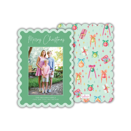 A family photo is displayed on a green scalloped card, with a pattern of Christmas ornaments and presents on the right side.