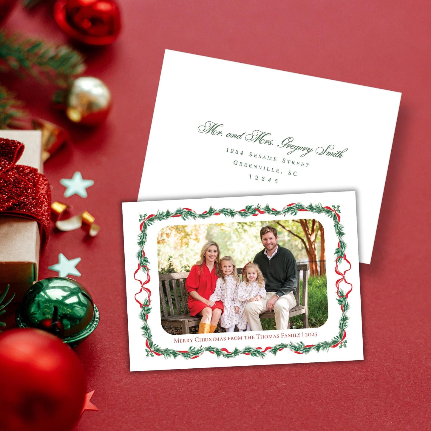 A Christmas card with a family photo of a man, woman, and two children sitting on a bench, surrounded by holiday decorations such as ornaments, tinsel, and a star.