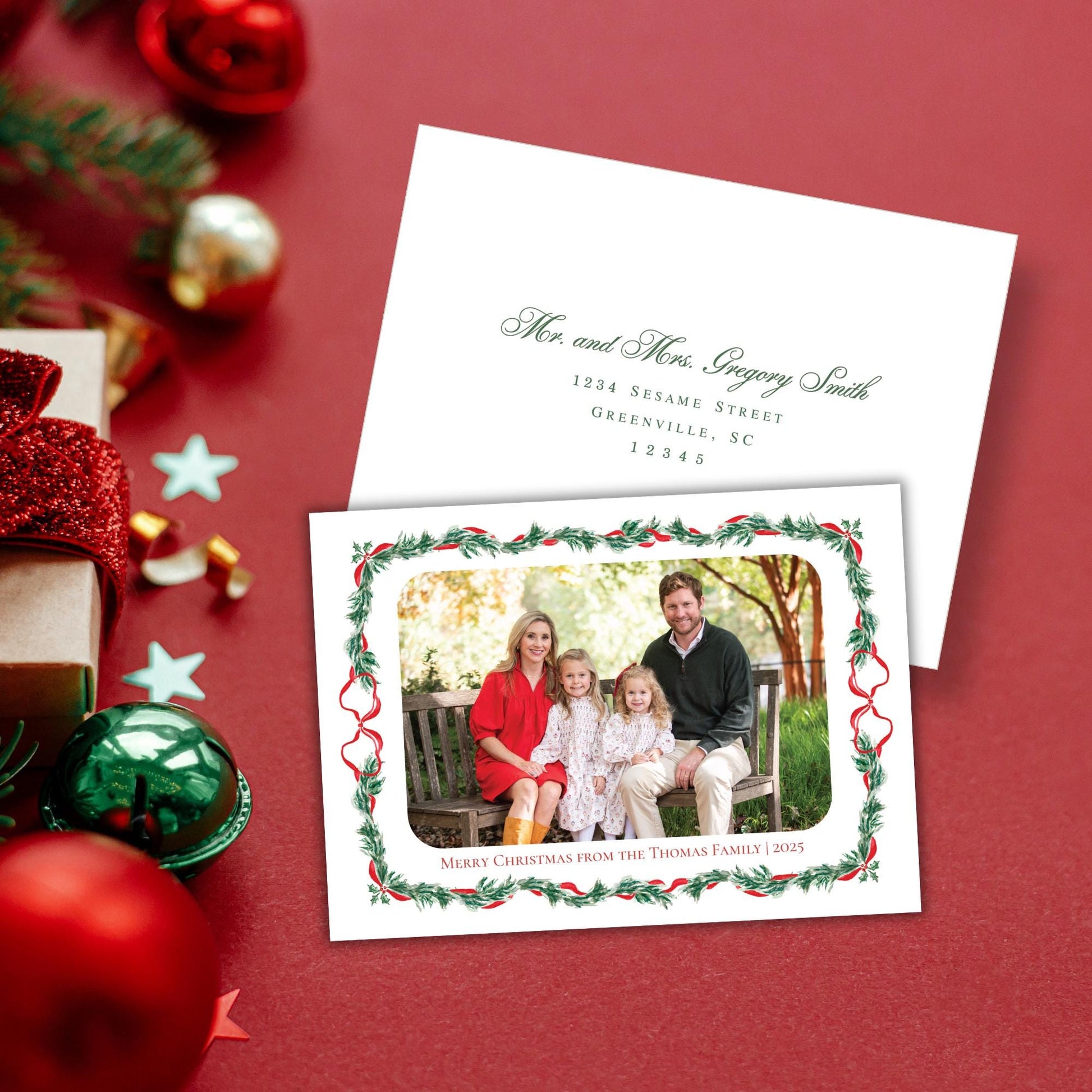 A Christmas card with a family photo of a man, woman, and two children sitting on a bench, surrounded by holiday decorations such as ornaments, tinsel, and a star.