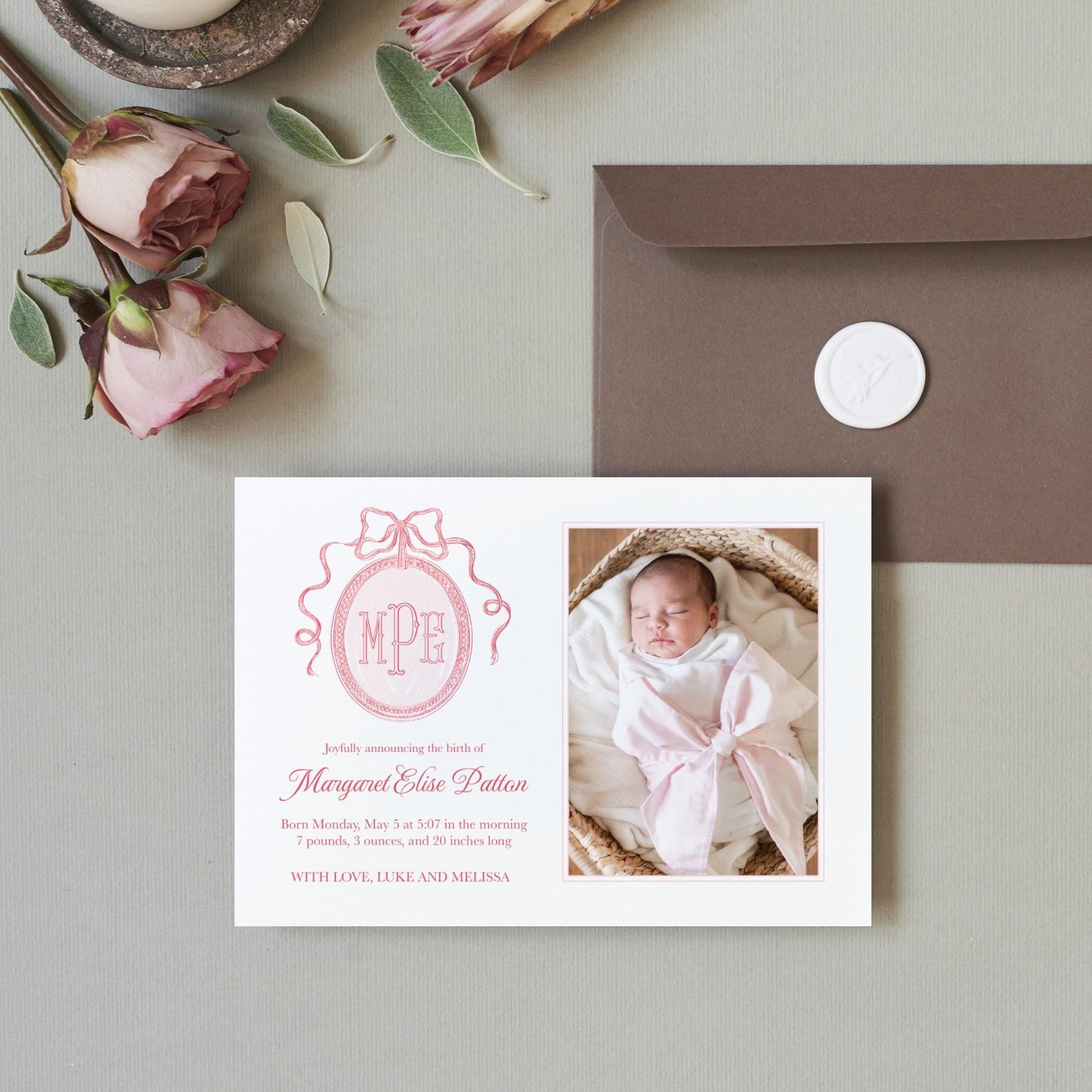 a photo of a baby girl on a card next to a envelope
