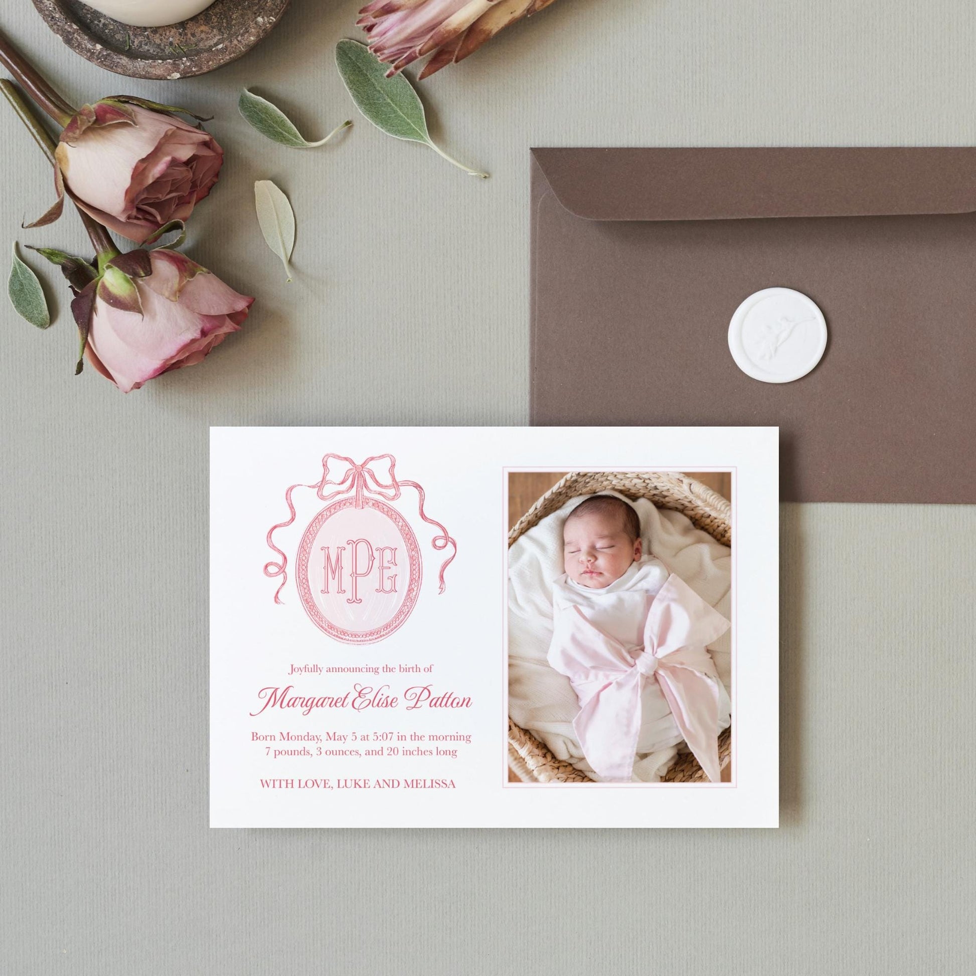 a photo of a baby girl on a card next to a envelope
