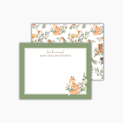 A rectangular 5.5 x 4.25 inch (A2 sized) flat notecard with a medium green border and a hand-painted watercolor fox in the bottom right corner. A name is at the top in a classic brown serif font. The back of the card features a watercolor pattern of forest woodland animals. Perfect "From the nursery of" notecard, great for baby stationery and baby shower thank you notes.