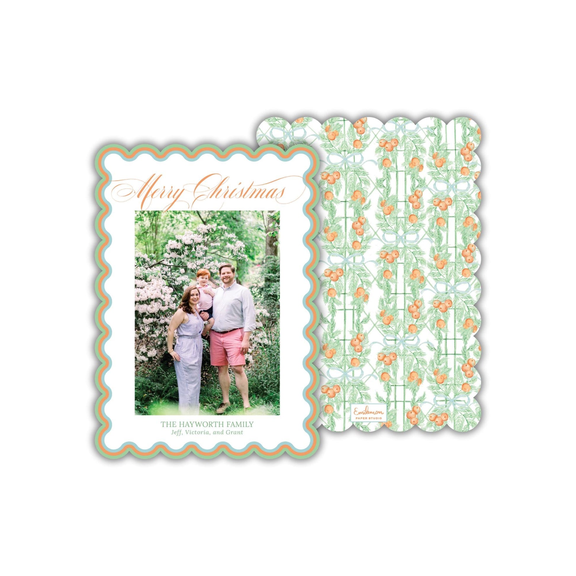 A family portrait of a man, woman, and child in a garden setting, with a scalloped edge frame and a repeating pattern of orange flowers on a green background.