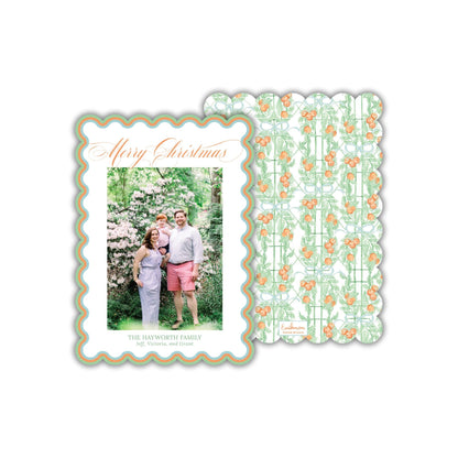 A family portrait of a man, woman, and child in a garden setting, with a scalloped edge frame and a repeating pattern of orange flowers on a green background.