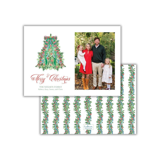 A family portrait of a family of four, with a Christmas tree design in the background, and a text overlay that reads &quot;Merry Christmas&quot; and &quot;THE NIESEN FAMILY&quot; along with the names &quot;Robert, Anne, and Claire&quot;.