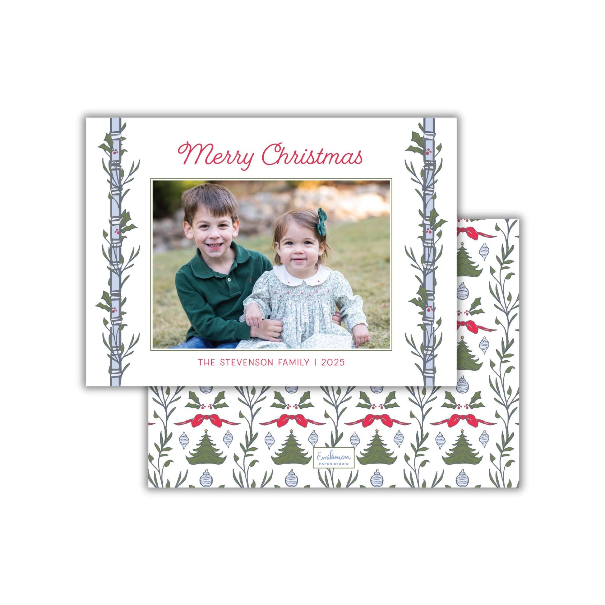 A Christmas-themed greeting card featuring a photo of two children, a boy and a girl, sitting together in a festive setting.