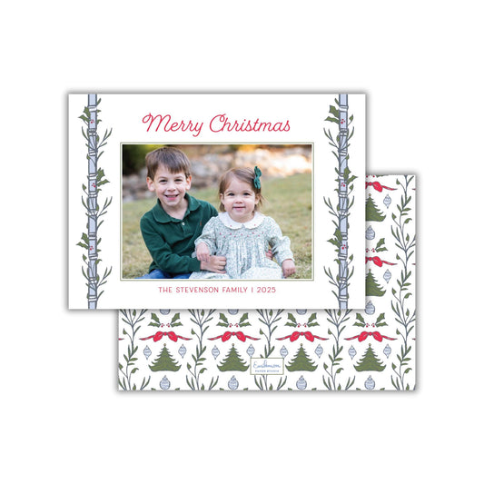 A Christmas-themed greeting card featuring a photo of two children, a boy and a girl, sitting together in a festive setting.