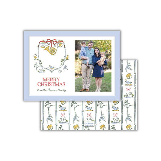 A family portrait of a man, woman, and child, along with a Christmas-themed design featuring a horn, flowers, and birds.