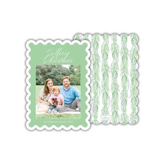 A family portrait of a man, woman, and child sitting together on a blanket in a grassy outdoor setting.