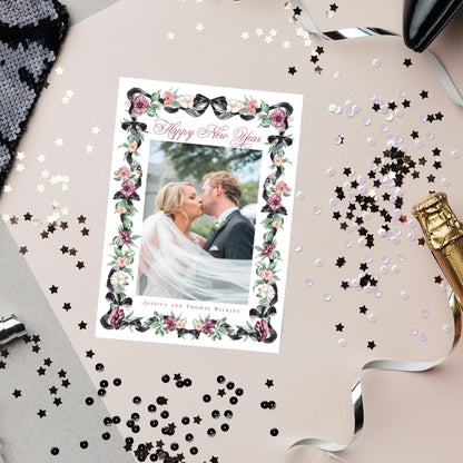 A wedding invitation card with a couple kissing in the center, surrounded by confetti, sequins, and a champagne bottle.