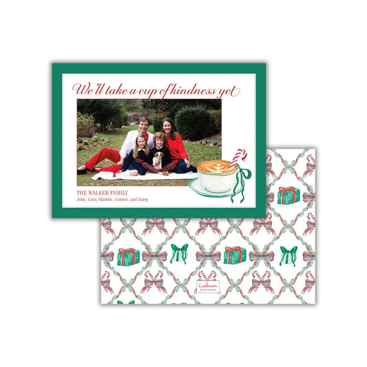 A family photo is displayed on a green and white card with a festive holiday theme, accompanied by a patterned envelope featuring a Christmas-themed design.
